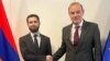 Armenian Deputy Foreign Minister Vahan Kostanian (left) and EU diplomat Enrique Mora shake hands in Brussels on November 15.