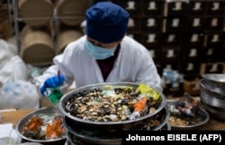 A woman mixes medicine in the pharmacy of Yueyang Hospital, which is part of the Shanghai University of Traditional Chinese Medicine. (file photo)