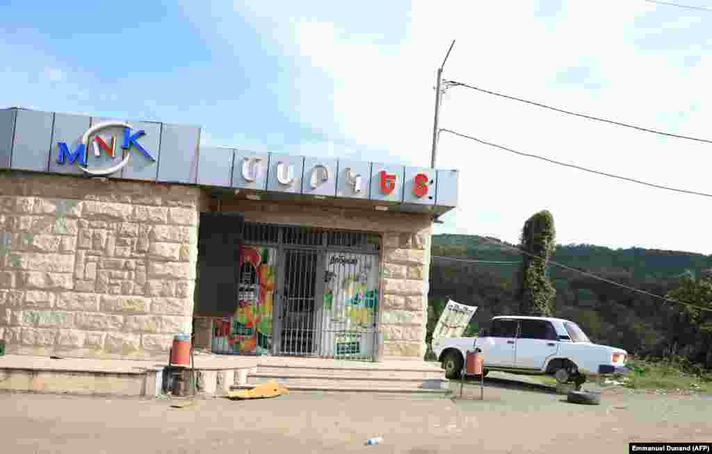 An abandoned vehicle is parked in front of a closed shop in Xankendi on October 2. The exodus of the region&#39;s people followed a&nbsp;24-hour campaign that began on September 19, when Azerbaijani forces routed the region&#39;s undermanned and outgunned Armenian forces, forcing them to capitulate.&nbsp;