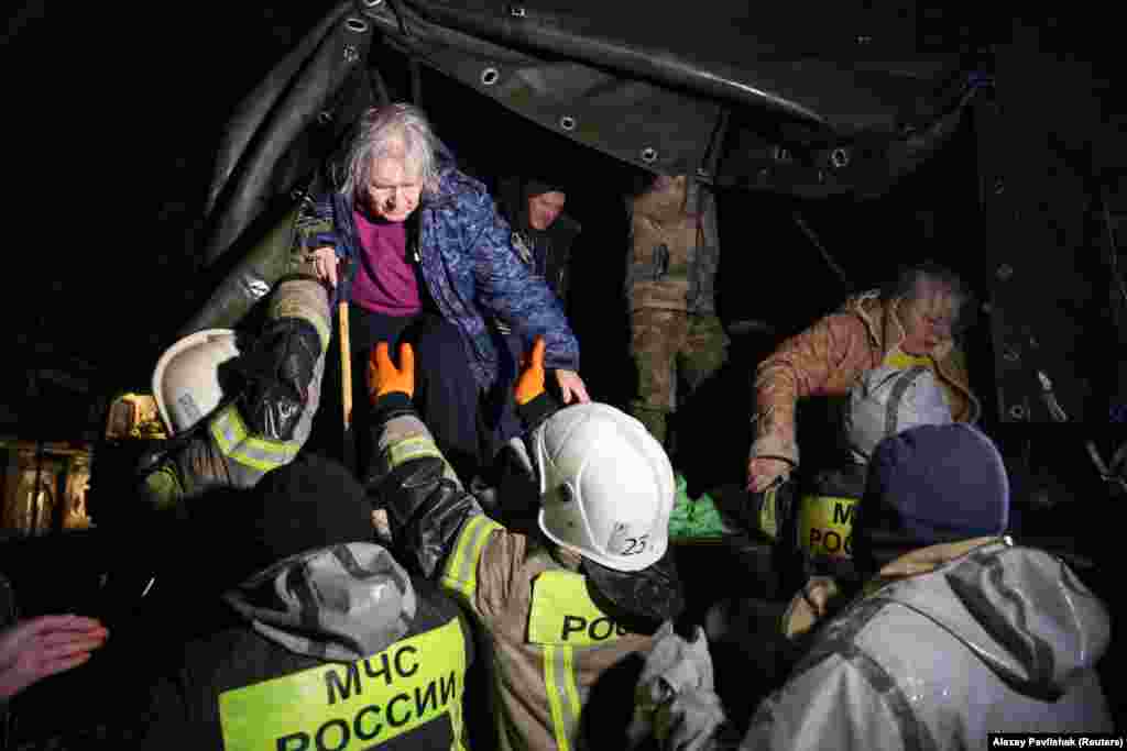 Local residents are helped out of a truck by rescuers during an emergency evacuation from a flooded street in the Crimean city of Yevpatoria on November 26. A Russian-installed official in the region that Moscow annexed from Ukraine in 2014, Oleg Kryuchkov, said one person had been killed. &nbsp;