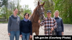 Turkmenistan's former president, Gurbanguly Berdymukhammedov (second from right), is seen visiting a horse center in Germany.