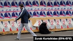 A man looks at campaign posters for opposition candidate Shalva Natelashvili in Tbilisi on October 22.