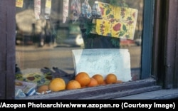 Oranges for sale in a shop window. The sign says: "Oranges, very sweet. 13 lei per kilogram."