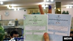 An Iranian voter holds up her ballot at a polling station in Tehran on June 12.