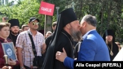 Moldovan President Igor Dodon (right) greets an Orthodox bishop during an anti-LGBT march in Chisinau on May 12.