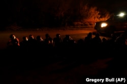 A group of migrants wait along a road after turning themselves in upon crossing the U.S.-Mexico border in La Joya, Texas, in May.