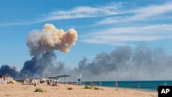 Smoke is seen from the beach at Saky after explosions were heard from the direction of the Russian military air base near Novofedorivka in Crimea in August