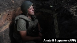 A Ukrainian soldier sits in a foxhole at a position along the front line in the Donetsk region on August 15.