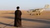 An Iranian cleric stands near a drone during a military exercise in an undisclosed location in Iran. The United States has placed sanctions on companies involved in the research and development of Iranian drones.