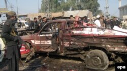 Pakistani security officials inspect the site of a bomb explosion at a Jamrud bazaar in Pakistan.