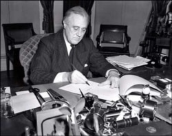 U.S. President Franklin D. Roosevelt signs the Lend-Lease Act on March 11, 1941.