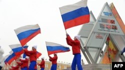 Performers wave Russian flags near the Sochi 2014 countdown clock just outside the Kremlin in Moscow in February 2013, a year ahead of the Games.