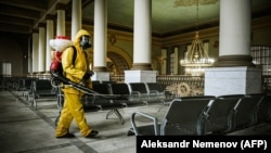 A worker from Russia's Emergencies Ministry disinfects a Moscow railway terminal amid a surge in COVID-19 cases.