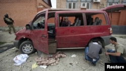 Investigators work at the site of a suicide bomb attack in the Malgobek Raion on August 19.