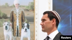 Turkmen President Serdar Berdymukhammedov with a portrait of his father, Gurbanguly, in the background. (file photo)