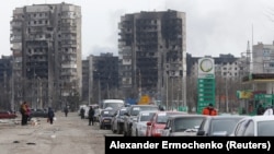 A line of cars is seen near blocks of flats destroyed by Russian shelling as evacuees attempt to leave the besieged port city of Mariupol on March 17.