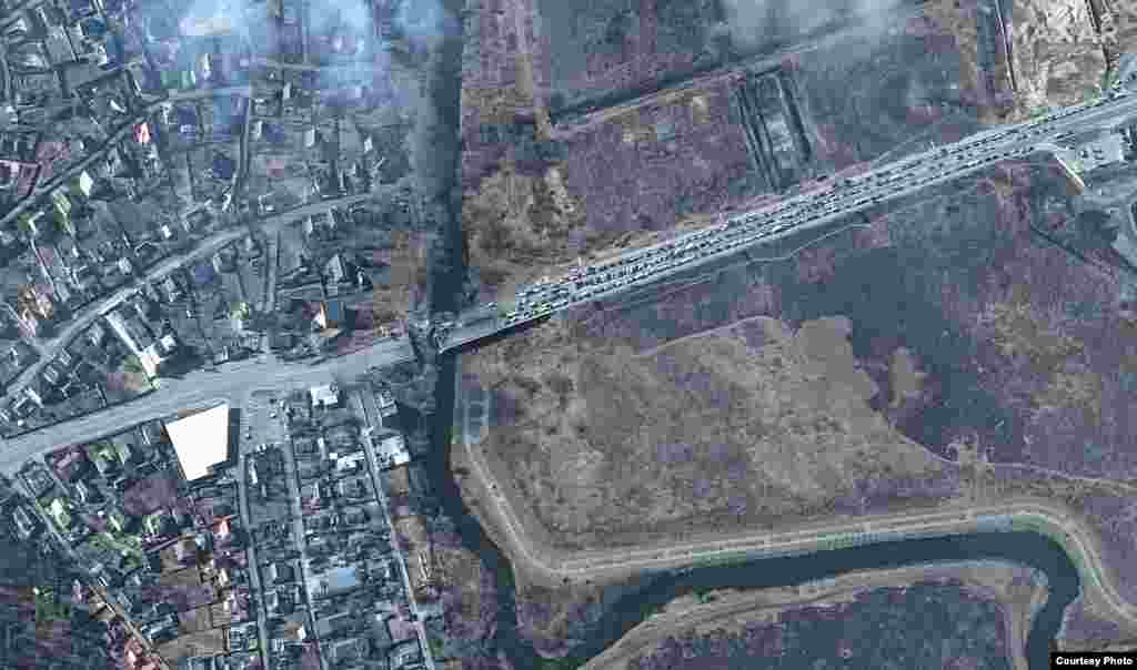 The destroyed bridge over the Irpin river and a huge backup of abandoned cars on March 14.