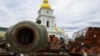 A child plays on top of an exhibition of destroyed Russian military vehicles and weapons outside St. Michael's Cathedral in Kyiv.