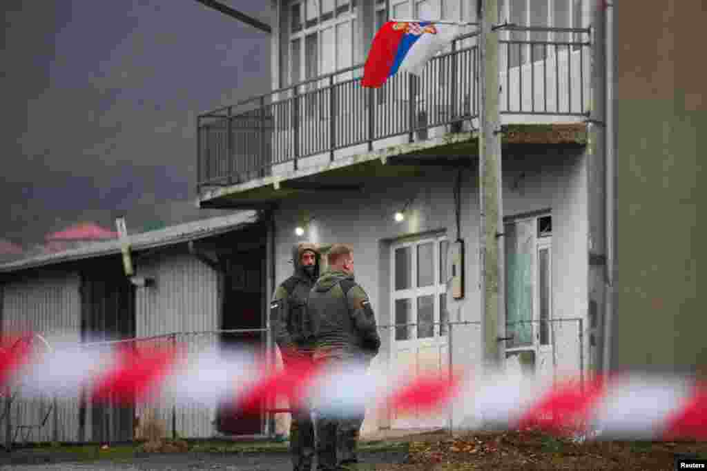 NATO peacekeepers from Germany walk near a roadblock set up by Kosovar Serbs in Rudare on December 12.