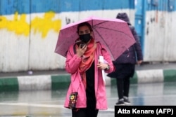 A woman walks with her hair uncovered through Tehran in December.