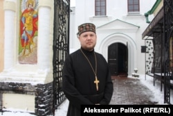 Priest Heorhiy Hulyayev stands in front of Kyiv's Pecherska Lavra.