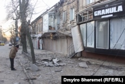 A man looks at the debris of shopfronts damaged in Russian shelling on the night of December 28.