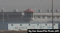 In a December 2018 photo, a guard tower and barbed-wire fences are seen around a facility in western China's Xinjiang region, one of a growing number of internment camps there.