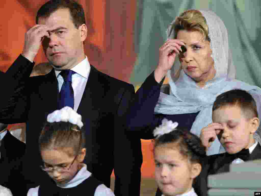 In Moscow, Russian President Dmitry Medvedev and his wife Svetlana cross themselves during a service on Christmas Eve.