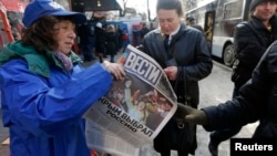 A woman hands out free newspapers with the headline "Crimea Chooses Russia" on a street in Simferopol, the Crimean republic's capital, on March 17.