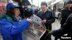 A woman hands out free newspapers with the headline "Crimea Chooses Russia" on a street in Simferopol on March 17.