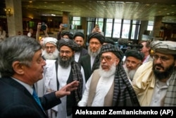 Russia's special presidential envoy for Afghan affairs, Zamir Kabulov (left), speaks to the Taliban's top political leader, Mullah Abdul Ghani Baradar (third from left), and other members of the Taliban delegation at peace talks in Moscow in May 2019.