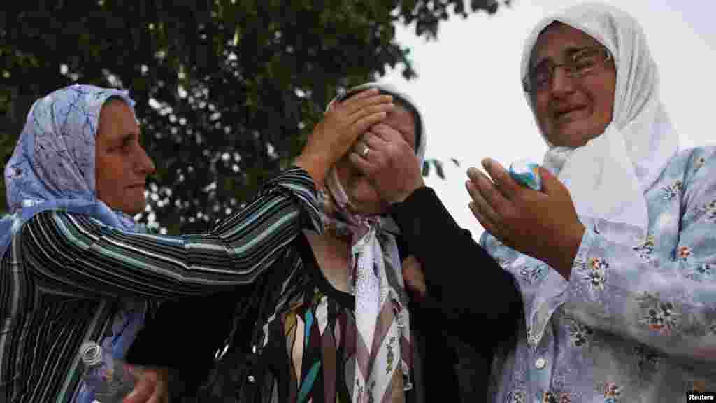 Women weep as trucks carrying the 520 coffins leave Visoko morgue on July 9 on their way to Sarajevo and the cemetery at Potocari.