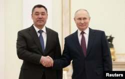 Russian President Vladimir Putin (right) poses with Kyrgyz President Sadyr Japarov during their meeting at the Kremlin in Moscow on May 8.