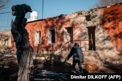 A worker pulls a cart in front of the hospital's maternity unit damaged by Russian shelling in Kherson on December 28.