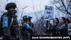 Government-backed Azerbaijani protesters identifying themselves as environmentalists stand in front of Russian peacekeepers last month.