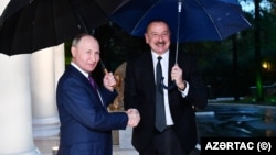 Russian President Vladimir Putin (left) and Azerbaijani President Ilham Aliyev shake hands after a meeting in Sochi in October 2022.