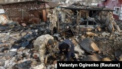 Investigators work at the site of a residential a building damaged during a Russian drone strike in the village of Stari Bezradychi in the Kyiv region on December 19.