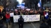 Hundreds of protesters, many of them expatriate Russians who fled the country rally to mark 10 months since Russia invaded Ukraine in Belgrade in December 2022. The Russian banner at the front says, "Peace for Ukraine, freedom for Russia."
