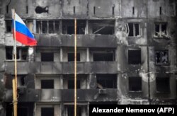 A Russian flag flies next to buildings destroyed by Russian shelling in Mariupol on April 12.