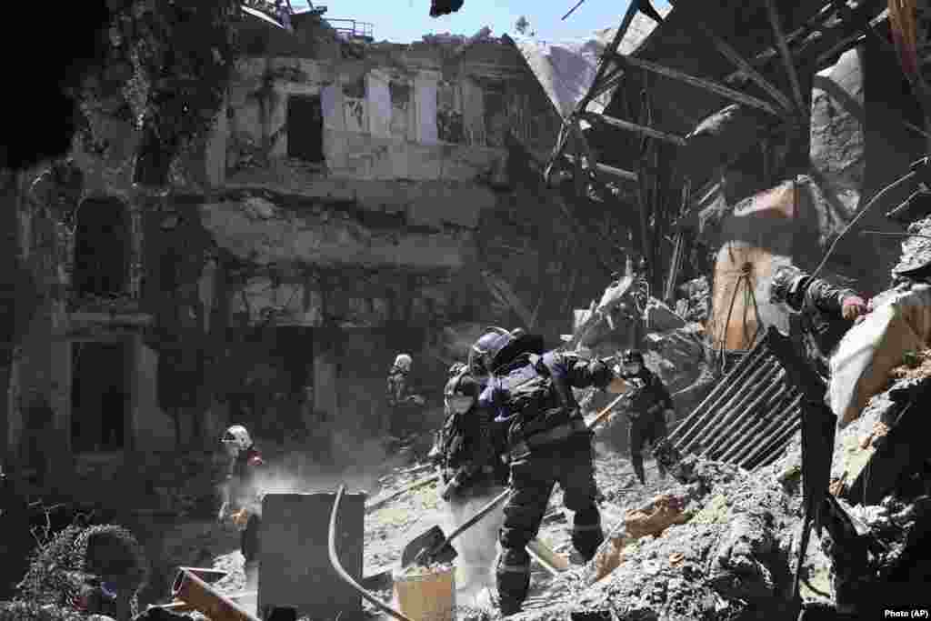 Employees from the local separatist-controlled government clear rubble from the Mariupol theater on May 12. An AP investigation estimated that 600 civilians died when Russia attacked the theater while it was being used as a bomb shelter. &nbsp;