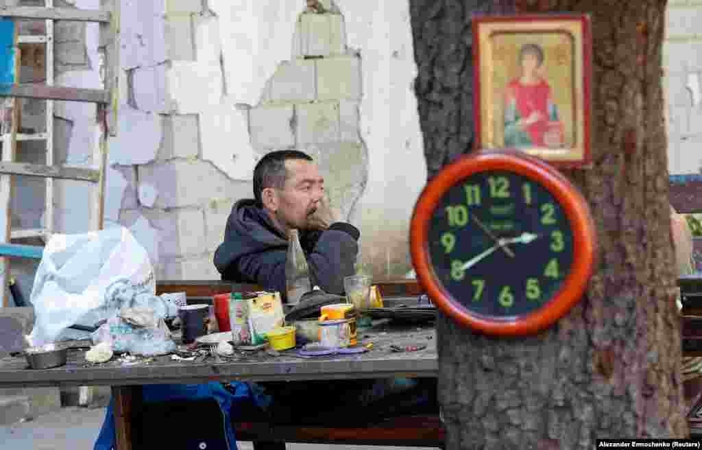 A resident sits in a shattered courtyard on May 12. Ukrainian news site 0629.com.ua reported on May 12 that Russia expected an outbreak in cholera in Mariupol due to the lack of clean water and poor sanitary conditions.