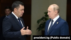 Kyrgyz President Sadyr Japarov (left) speaks with Russian President Vladimir Putin in Astana on October 13.