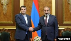 Armenian Prime Minister Nikol Pashinian (right) meets with Arayik Harutiunian, the ethnic Armenian leader in Nagorno-Karabakh, in Yerevan on October 12, 2022.