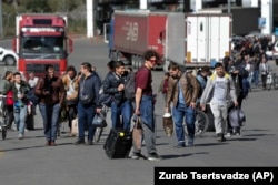 A group of Russians walk after crossing the border at Verkhny Lars in Georgia on September 27, 2022.