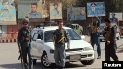 Afghan policemen keep watch in the downtown of the city of Kunduz on October 3.