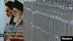 A poster of Iranian Supreme Leader Ayatollah Ali Khamenei and the late Ayatollah Ruhollah Khomeini is seen next to a bank of centrifuges in what is described by Iranian state TV as a facility in Natanz.