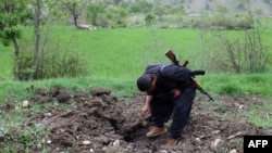 A Kurdish PJAK (Free Life Party of Kurdistan) rebel inspects an alleged Iranian artillery crater near Qandil, in Iraq, in April 2008.