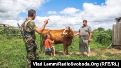 Архивное фото: украинский военный расспрашивает жителей Чермалыка о последствиях обстрела