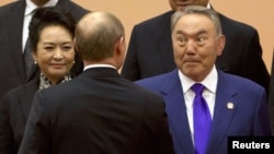 "'No statehood,' you say?!" Kazakh President Nursultan Nazarbaev (right) reacts during a handshake with Russian President Vladimir Putin at a summit in Shanghai, China in late May.