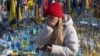 A woman cries at the memorial to the fallen Ukrainian soldiers on Independence Square in Kyiv on February 24.